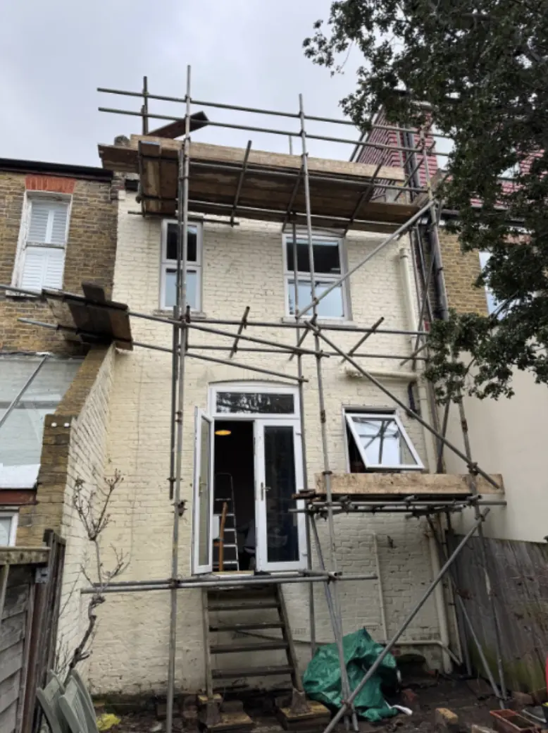 Rear of a terraced house scaffolded for extension work