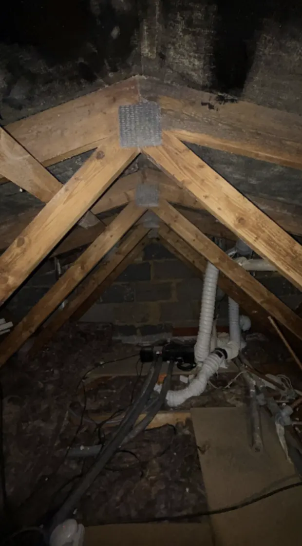 Empty trussed loft with bare joists before any insulation is laid